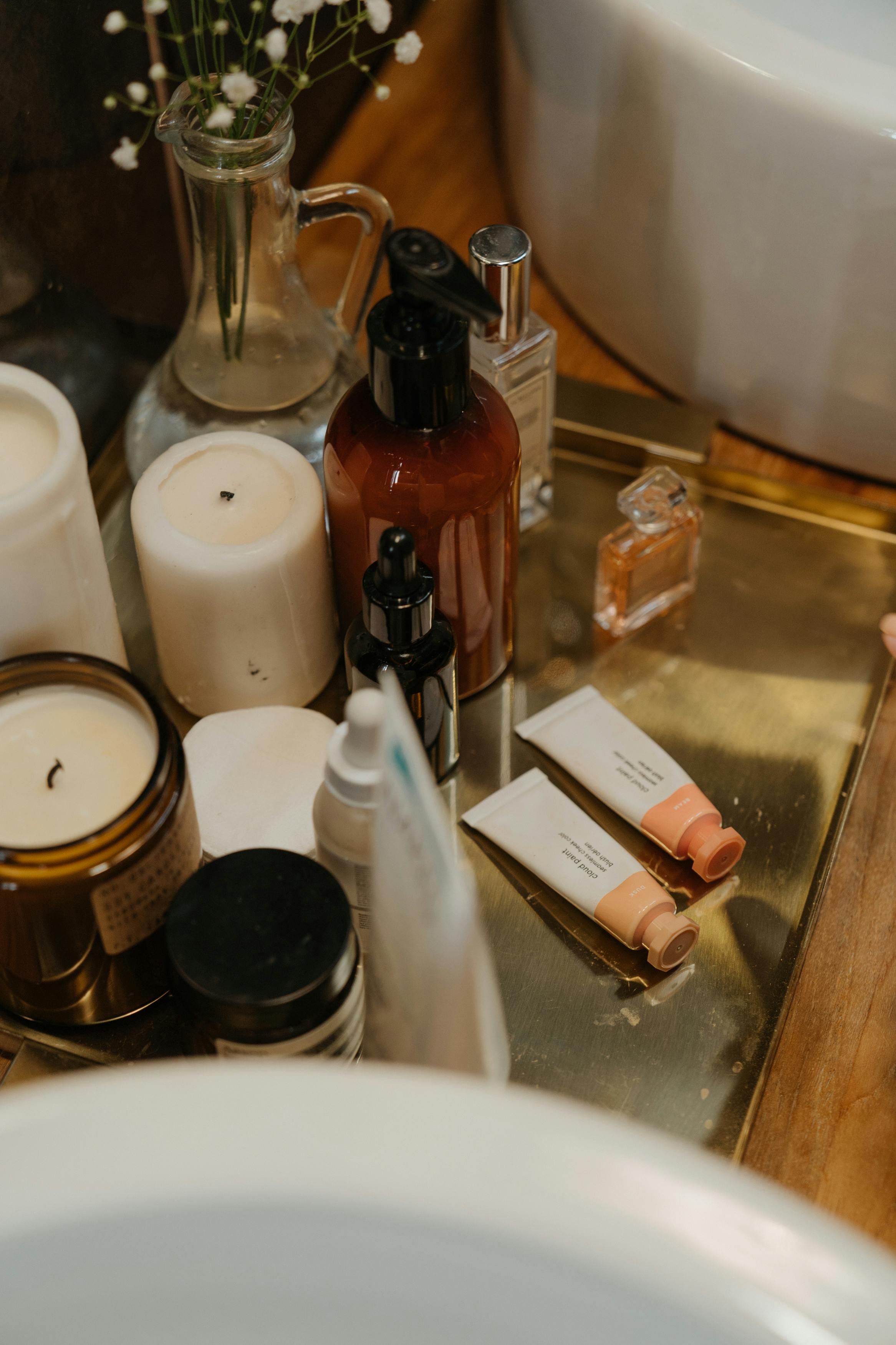 selection of skincare and lip balm products aesthetic looking on a mirror tray in bathroom close up