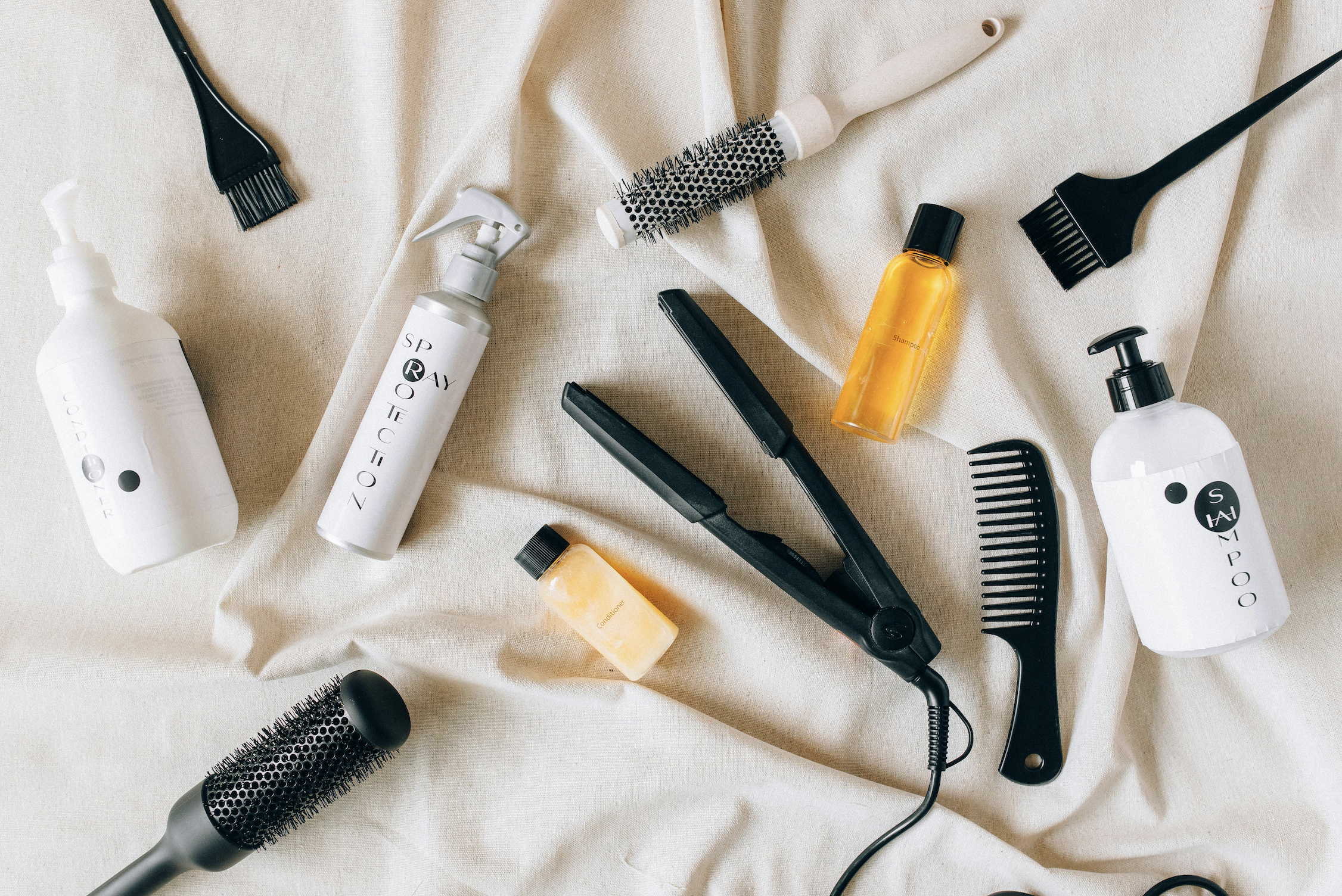 selection of hair care products including butane free natural dry shampoo bottle, combs and hair tools