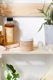 close up Organic Hydrating Facial Moisturizer with Aloe & Rosehip Oil opened product image in aesthetic shelf backdrop with rose quartz and green leaves