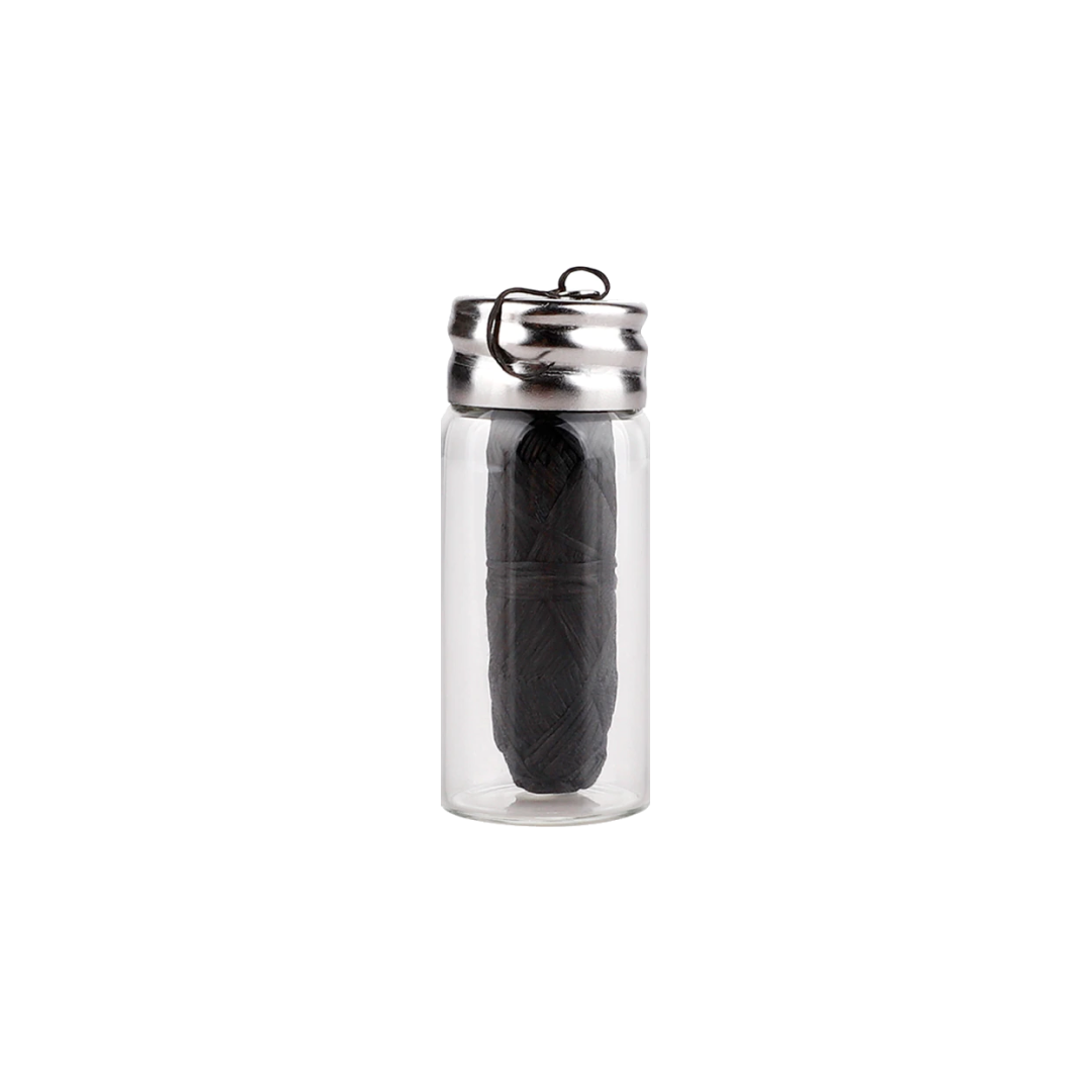 Biodegradable black Charcoal Dental Floss in glass bottle with a white background