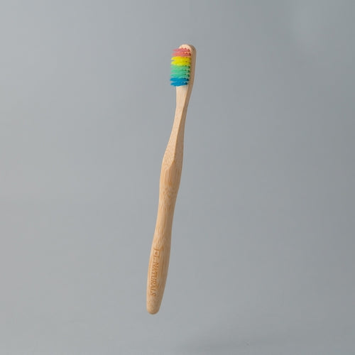 eco friendly bamboo toothbrush with rainbow charcoal bristles in white background