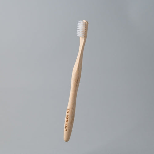eco friendly bamboo toothbrush with white charcoal bristles in white background