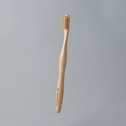 eco friendly bamboo toothbrush with white charcoal bristles in white background