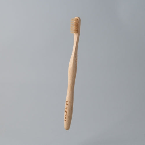 eco friendly bamboo toothbrush with white charcoal bristles in white background