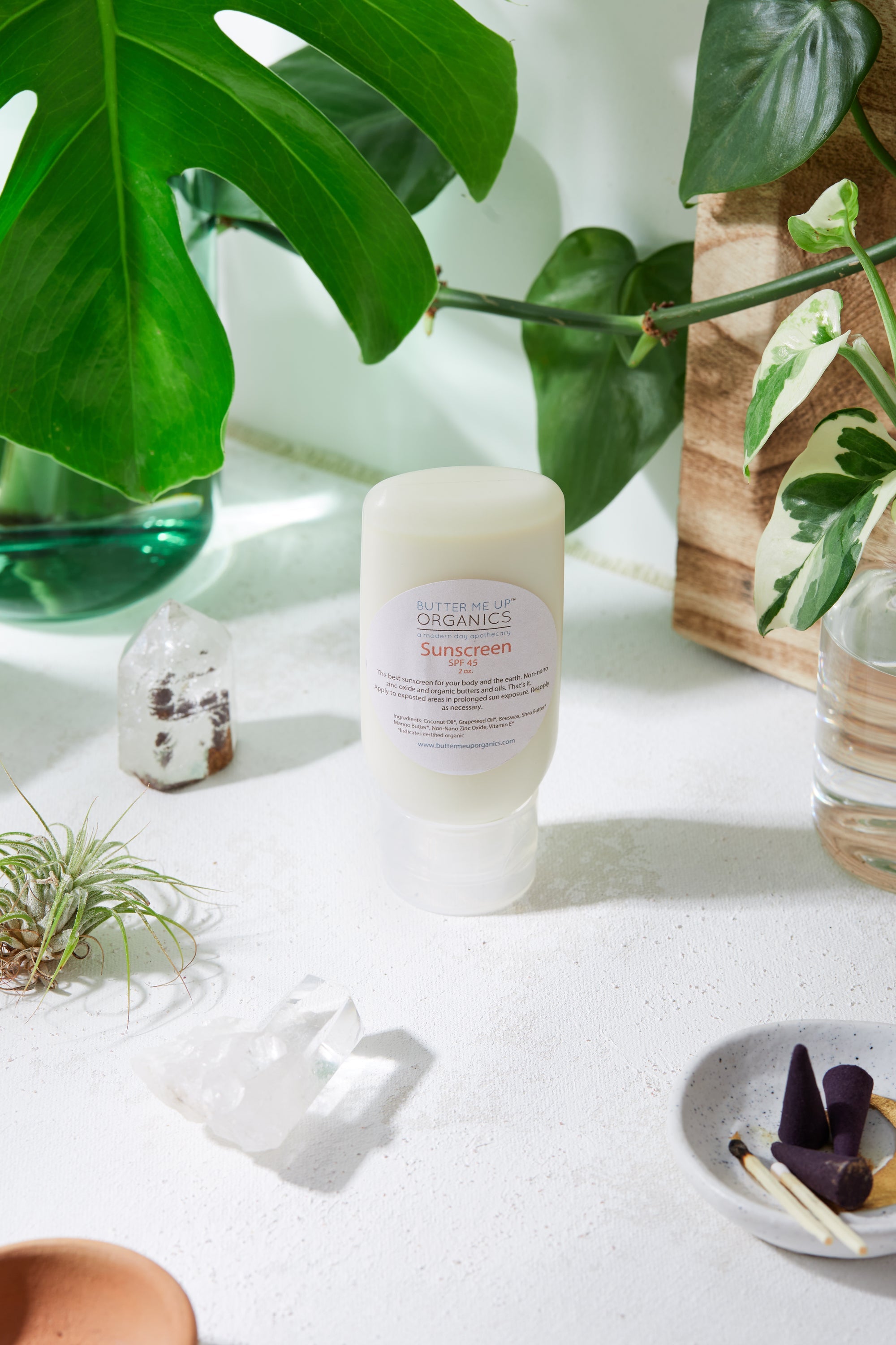 Natural Organic Sunscreen in roll on form with plants, crystals and cactus in background for visual aesthetic