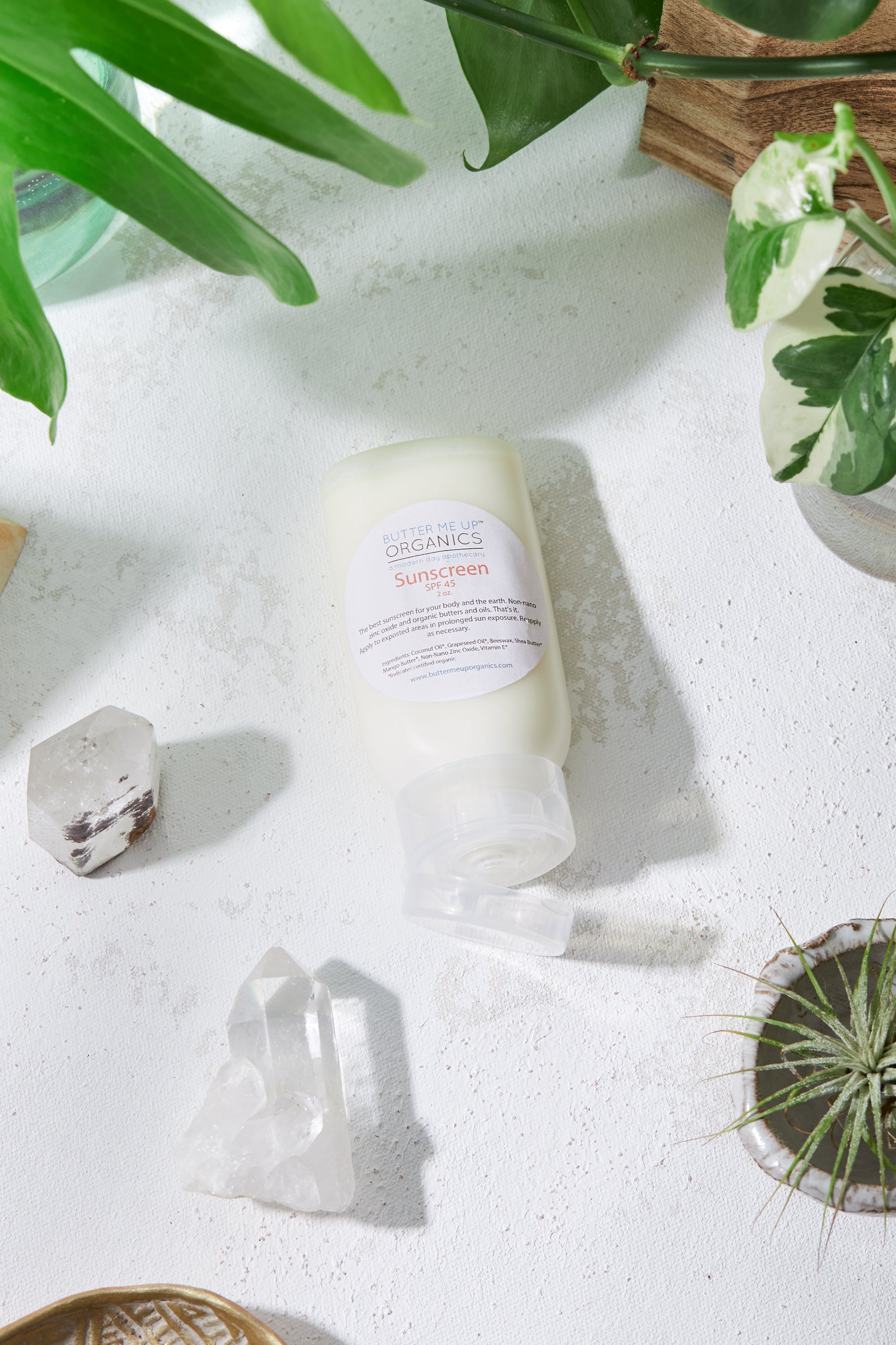 Natural Organic Sunscreen in roll on form with plants, crystals and cactus in background for visual aesthetic birds eye view shot
