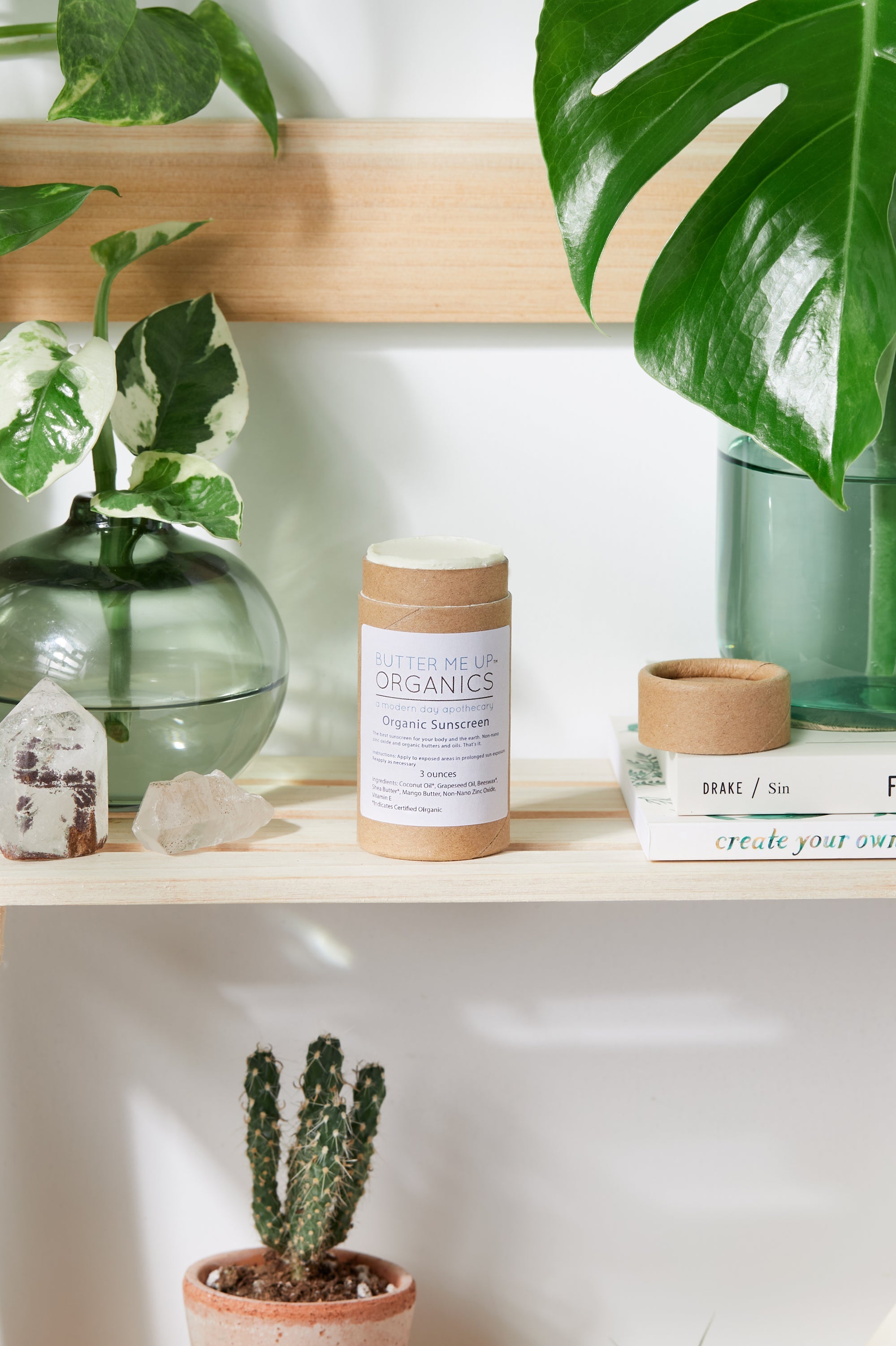 Natural Organic Sunscreen in balm packaging and form with plants and cactus in background for visual aesthetic