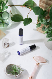 product image of Organic Caffeine Eye Repair Serum in 2x different size options in aesthetic white backdrop with green leaves and rose quartz