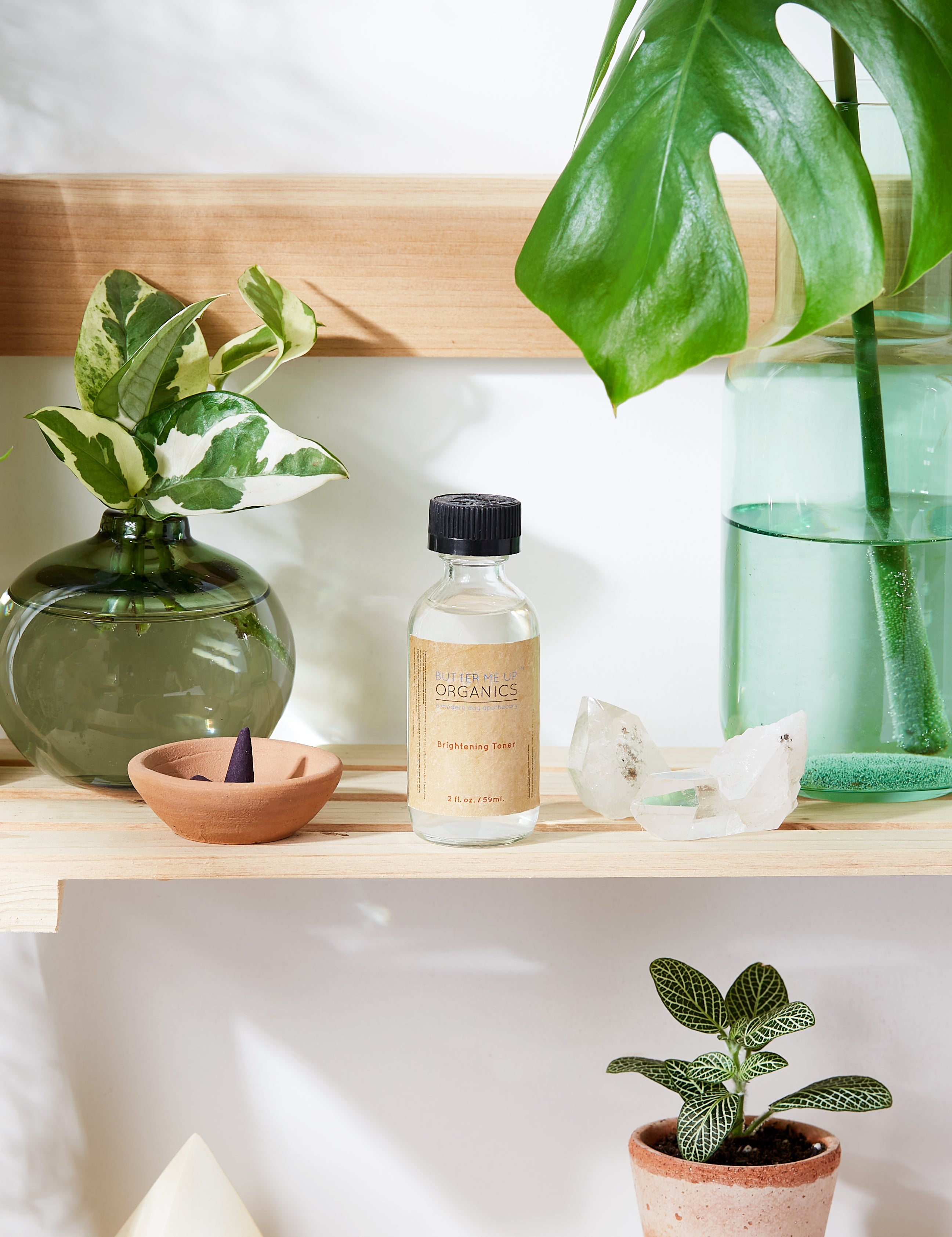 Organic Brightening Toner in aesthetic backdrop with crystals, green plants on a wooden shelf