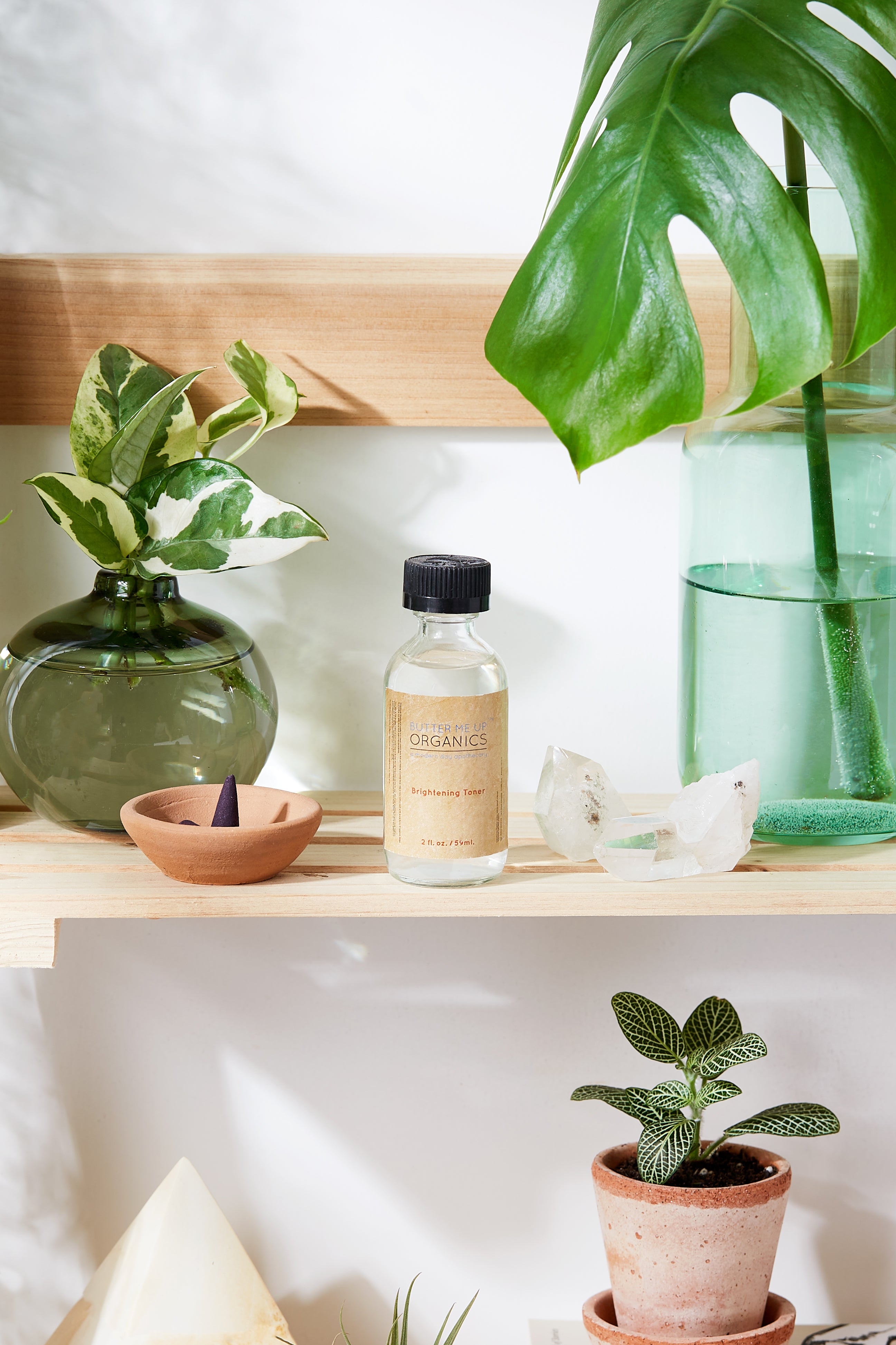 Organic Brightening Toner in aesthetic backdrop with crystals, green plants on a wooden shelf