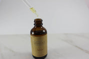 Organic Hair Oil for Healthy, Shiny Hair opened product image with syringe showing the oil droplets in white minimalistic backdrop 