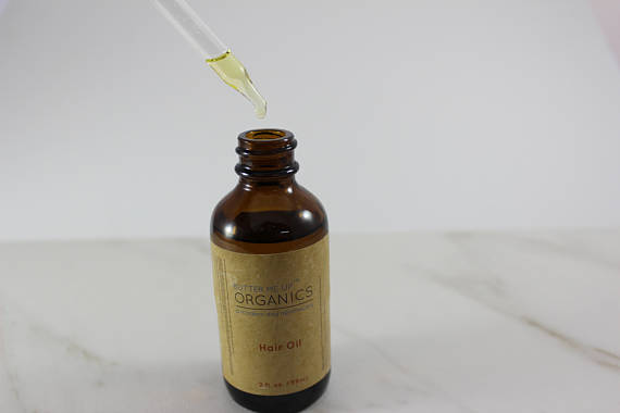 Organic Hair Oil for Healthy, Shiny Hair opened product image with syringe showing the oil droplets in white minimalistic backdrop 